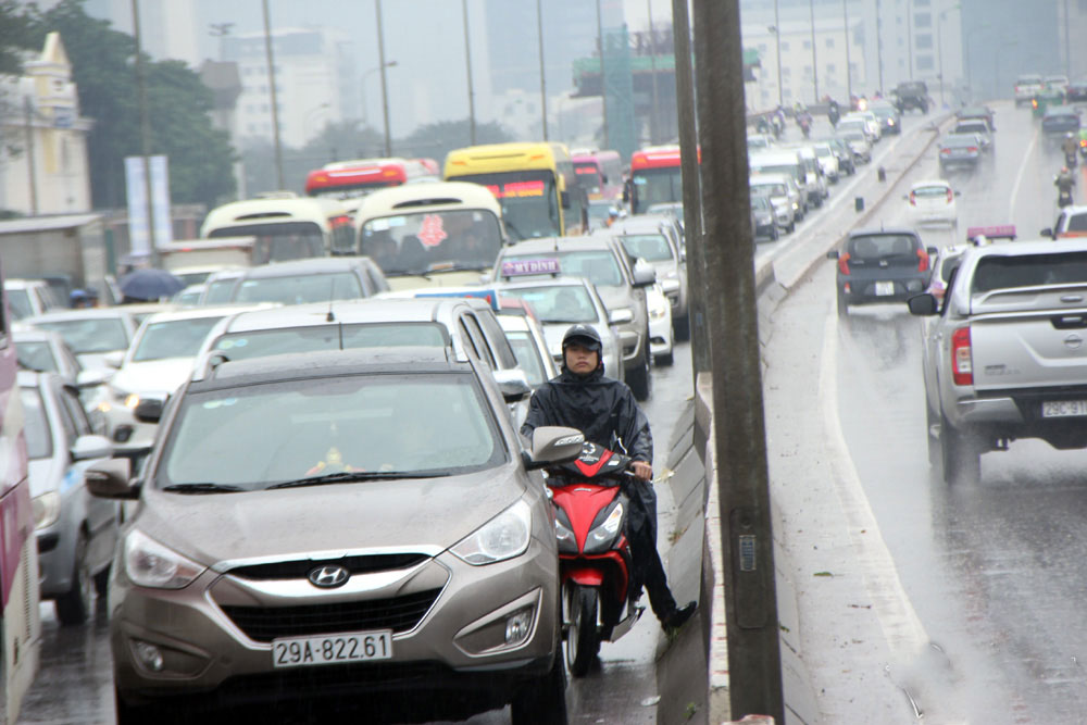 Vật vã chôn chân hít khói ô tô trong mưa rét Hà Nội